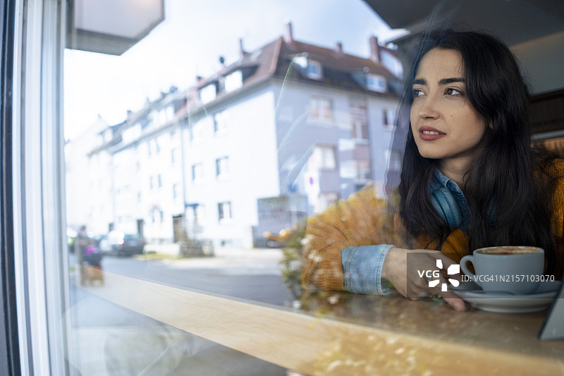 在咖啡馆靠窗沉思的女人图片素材