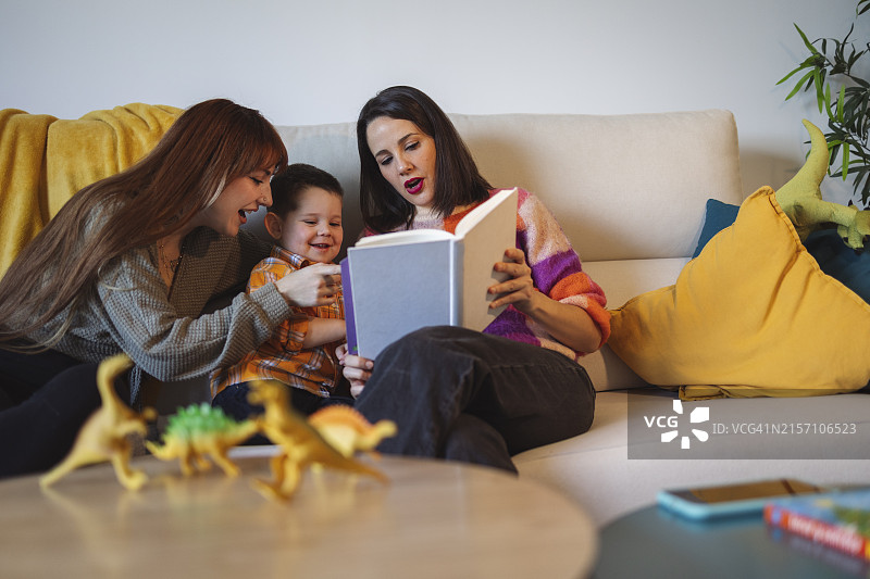 快乐的一家人在家里的沙发上看书图片素材