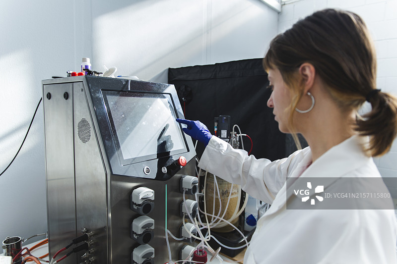 在实验室操作生物反应器的科学家图片素材