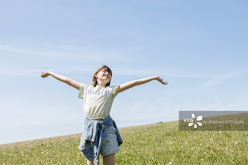 在蒲公英田中张开双臂的快乐女孩图片素材