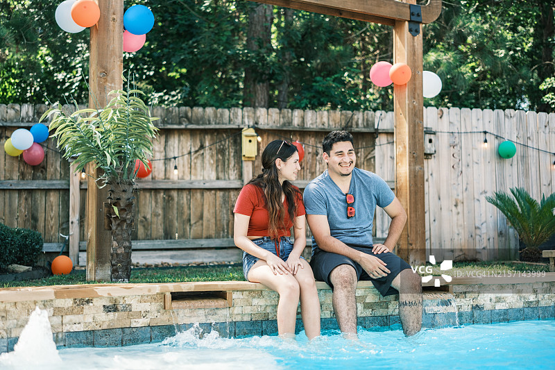 在后院派对泳池里享受的年轻拉丁裔人图片素材