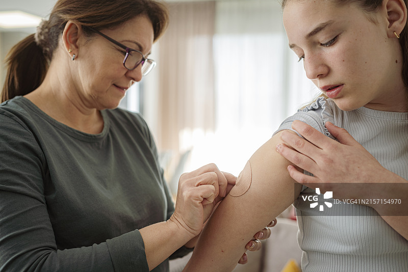 母亲给女儿手臂贴透皮贴片图片素材
