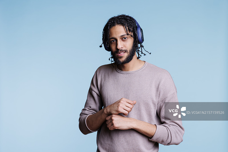 戴着耳机听音乐的阿拉伯男人图片素材