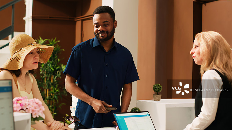 在酒店大堂办理入住和等待的商务人士或游客图片素材