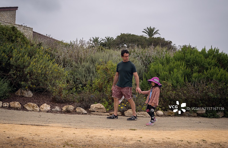 4岁女孩牵着爸爸的手走路图片素材