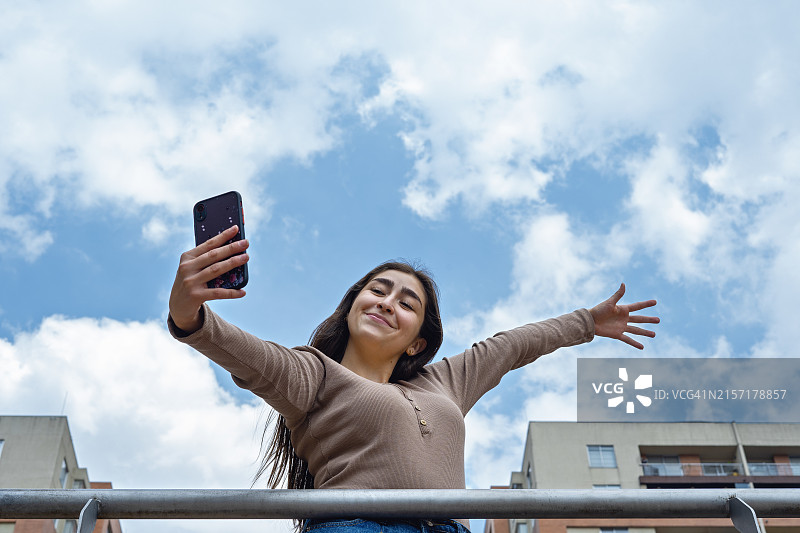 小女孩在户外用手机自拍图片素材