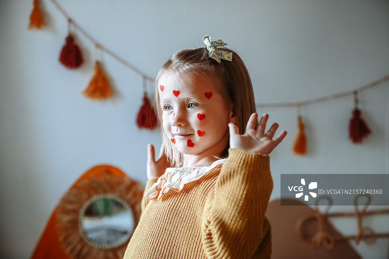 真挚的童真：脸上贴着爱心贴纸的迷人儿童的肖像，反映了心理健康图片素材