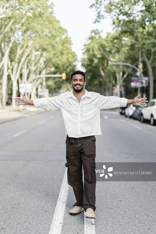 在城市里张开双臂表达自由的拉丁休闲男人图片素材