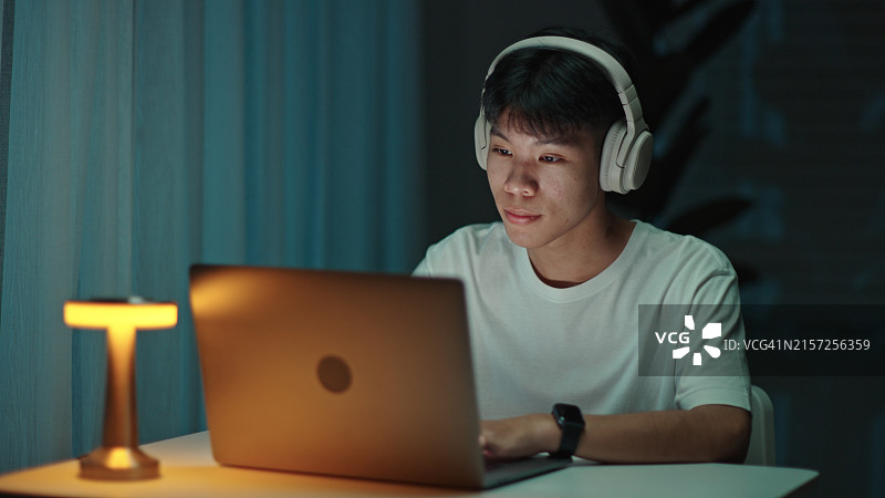 青少年夜晚使用笔记本电脑图片素材