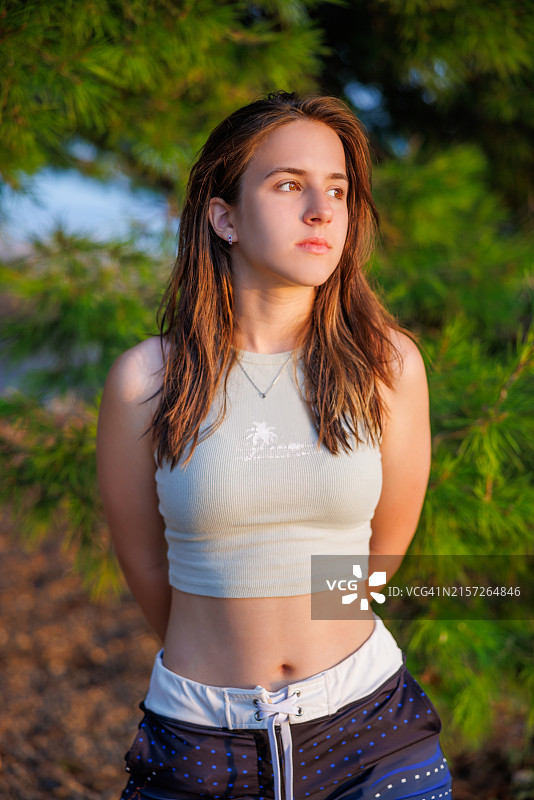 穿露脐装站在树旁沉思的可爱少女肖像图片素材