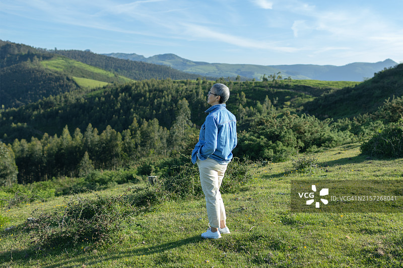 年长的女人在山中欣赏日落图片素材
