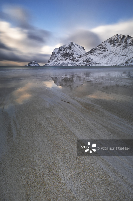 挪威罗弗敦群岛豪克兰海滩的午后阳光长曝光，山上有积雪图片素材