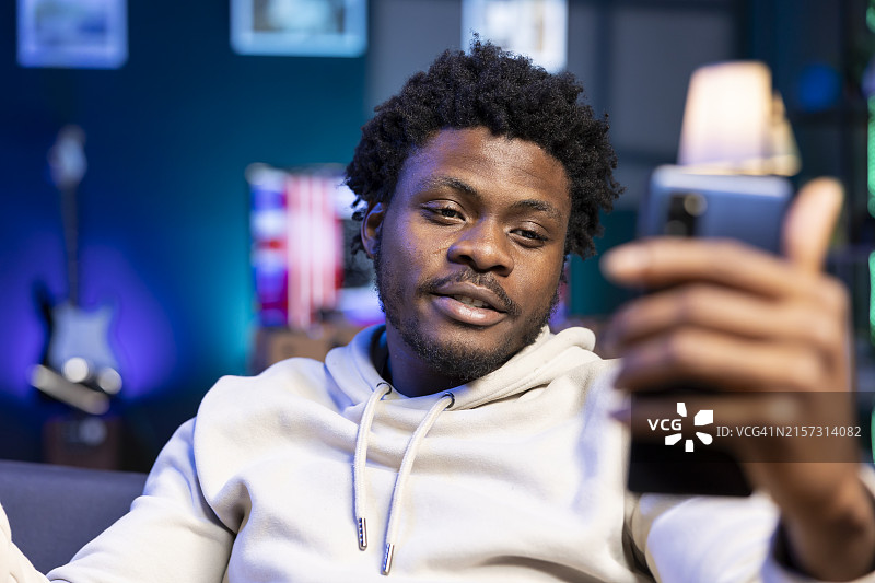 在家使用手机的年轻男人图片素材