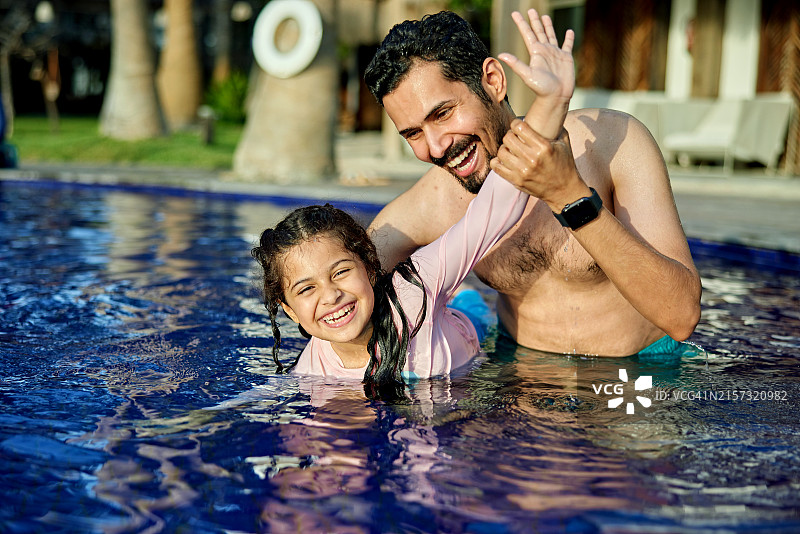 男人在游泳池里和女儿玩耍图片素材