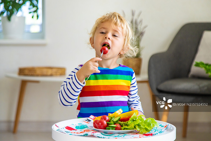 可爱的男孩在家吃沙拉图片素材