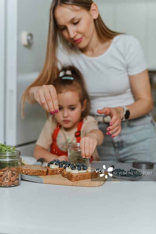 母亲教女儿制作花生酱面包早餐图片素材