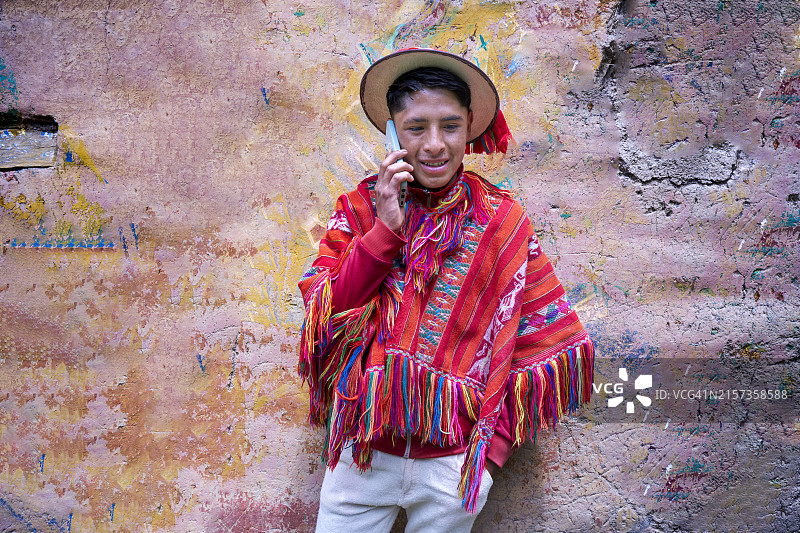 盖丘亚族少年在库斯科附近的安第斯山脉使用智能手机打电话图片素材