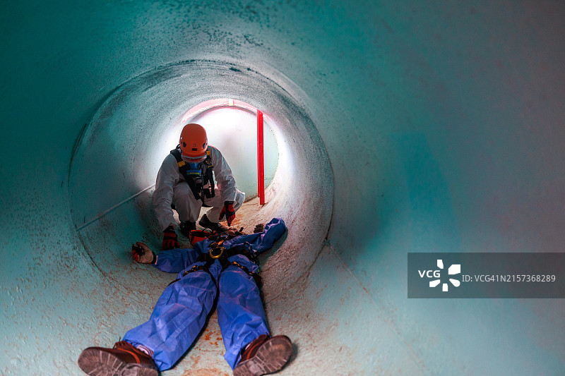 救援队协助受困管道的受害者图片素材