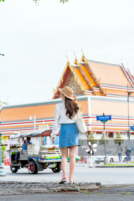 亚洲女游客在泰国曼谷玉佛寺和大皇宫前欣赏风景的背影图片素材