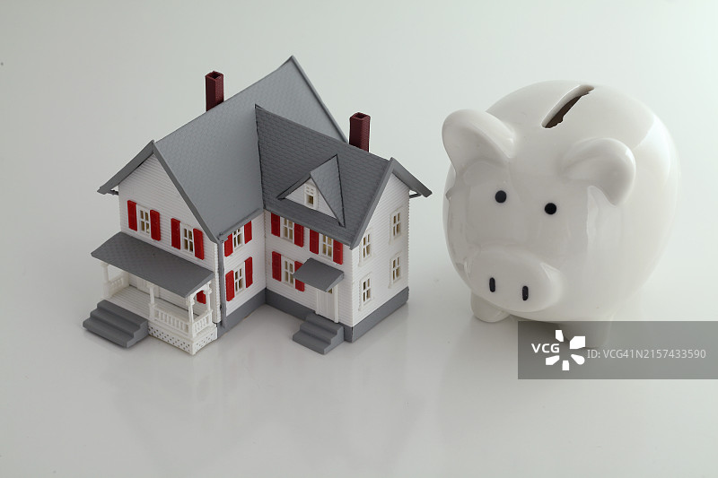 白色背景上的储蓄罐和模型房子图片素材