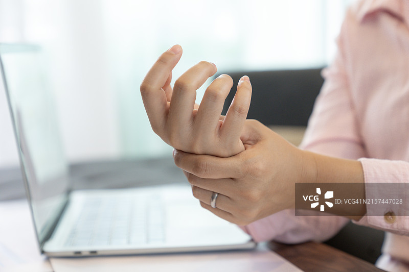 因使用电脑而手腕疼痛的女人图片素材