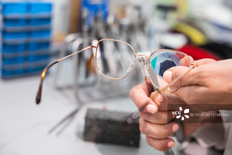 验光师将镜片放入眼镜的特写镜头图片素材