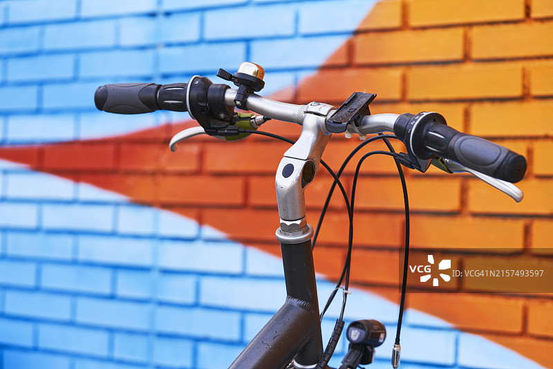 停放在蓝色壁画面前的自行车车把图片素材