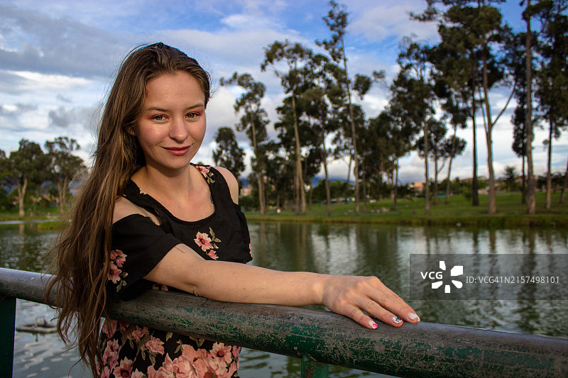 在日落时分的湖边的年轻漂亮女人图片素材