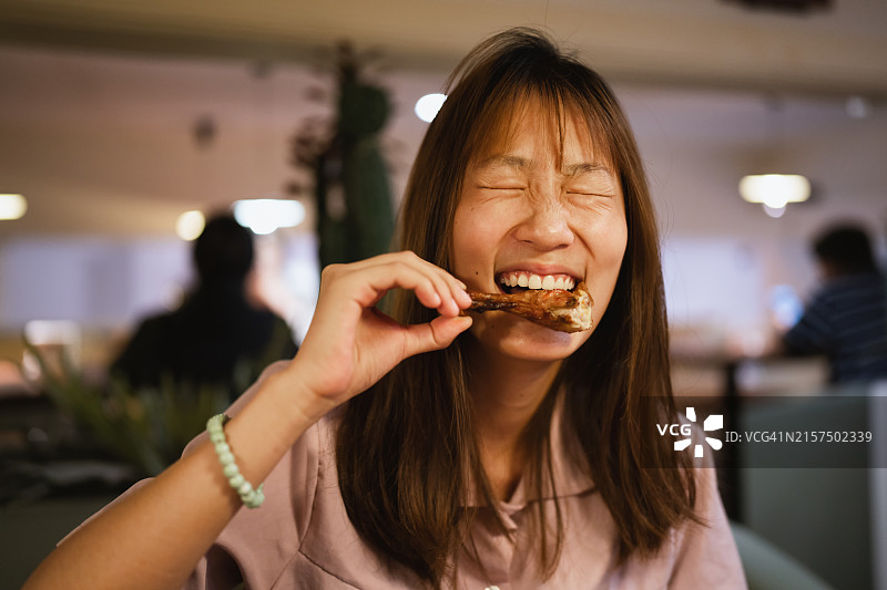 一位美丽的年轻亚洲女性在餐厅用餐。图片素材