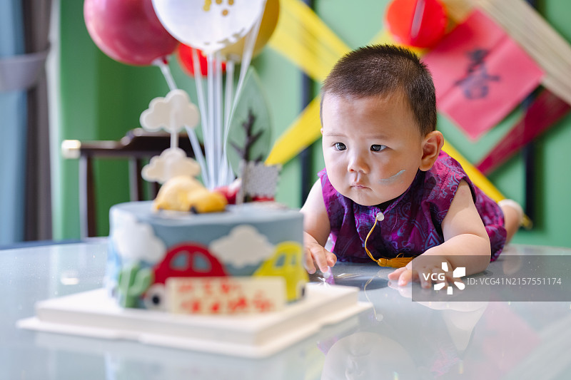 小男孩看着他的第一个生日蛋糕图片素材