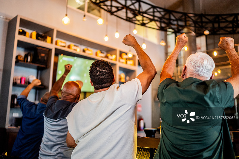 在酒吧观看足球比赛的年长男球迷图片素材