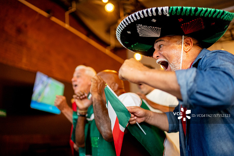 在酒吧庆祝足球比赛进球的墨西哥年长球迷图片素材