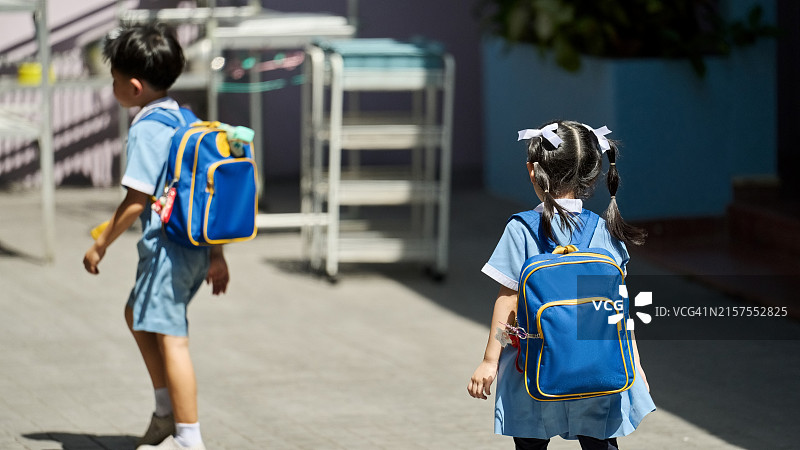 背着书包从学校回家的学龄前儿童图片素材