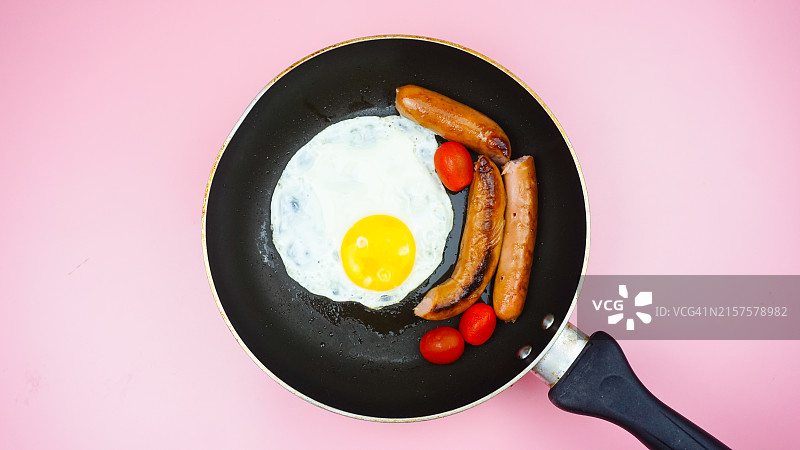 烤盘上的煎蛋香肠和圣女果早餐图片素材