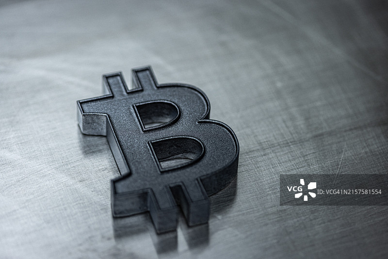 数字钱包和加密货币概念，数字货币和区块链技术，钢背景上的钛比特币图标，具有复制空间的简约设置，用深色石墨金属漆绘制的元素图片素材