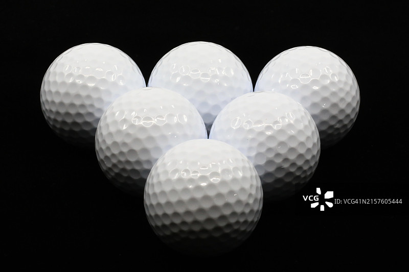 深色背景上排列的高尔夫球图片素材