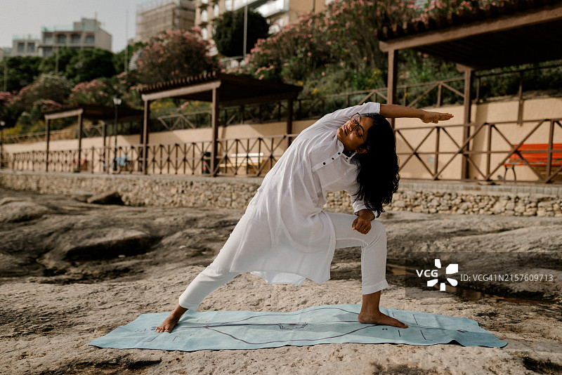 女子在清晨的海滩练习瑜伽图片素材