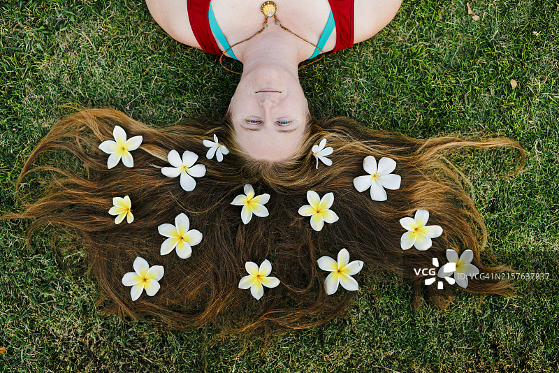 长发上戴着鸡蛋花花瓣的女人图片素材