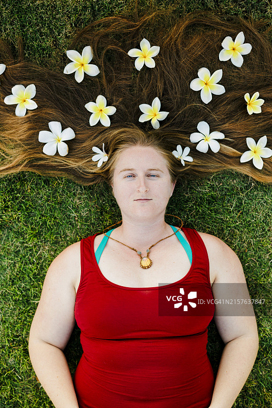 长发上戴着鸡蛋花花瓣的女人图片素材