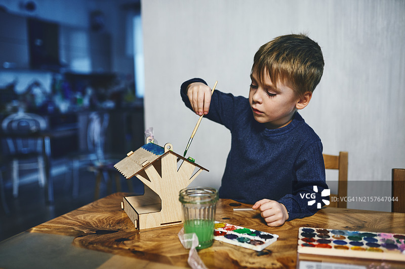儿童正在给木制模型上色图片素材