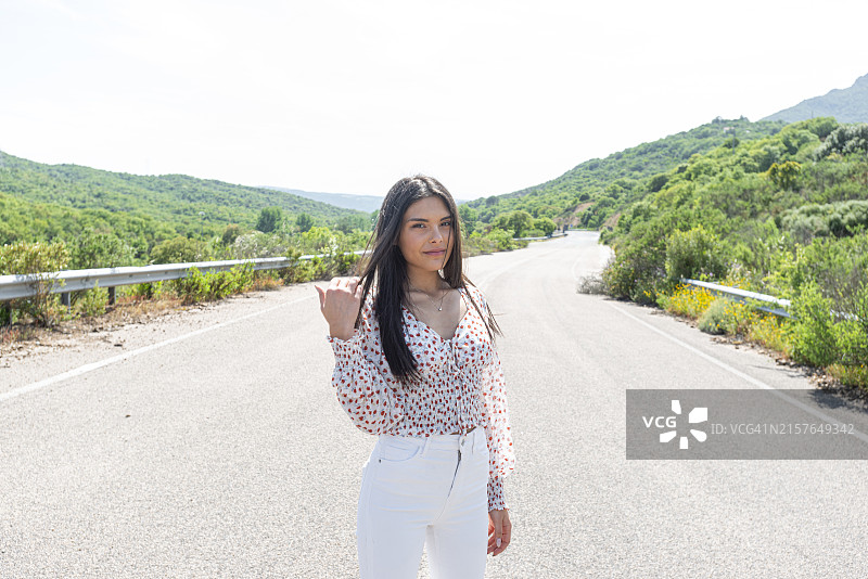 站在空旷道路上的年轻漂亮女子图片素材
