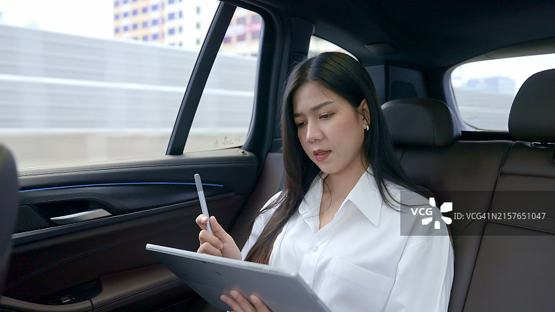 在车内使用平板电脑工作的女商人图片素材