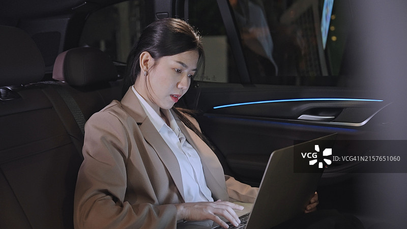 在车里用笔记本电脑工作的女商人图片素材