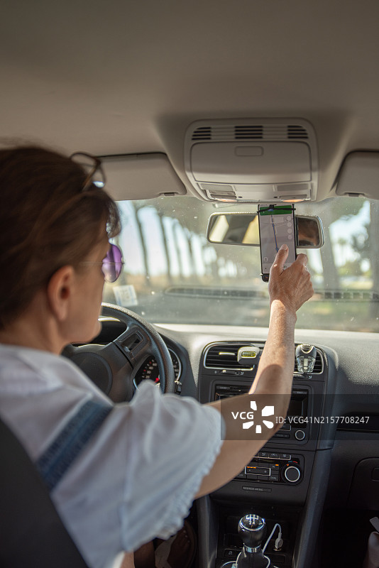 女司机使用智能手机上的GPS导航图片素材