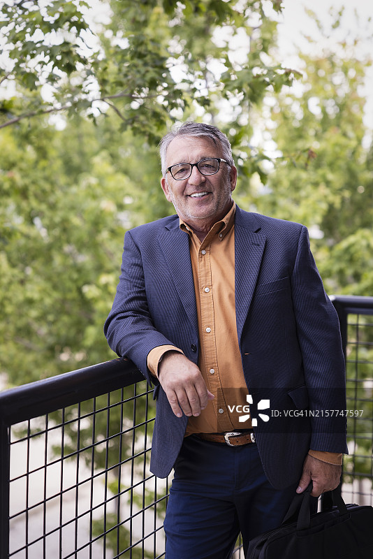 在阳台上拿着公文包的商务男士肖像图片素材