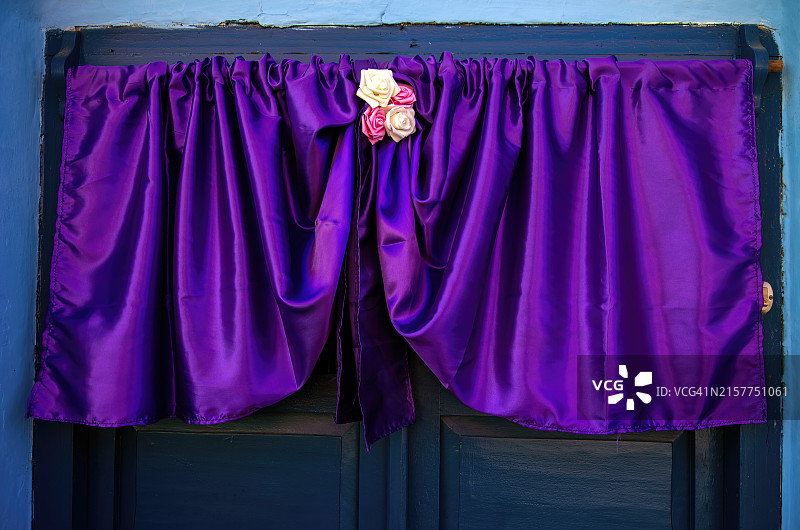 殖民风格房屋前门上方的圣周/圣周紫色帷幔和丝绸花卉装饰图片素材