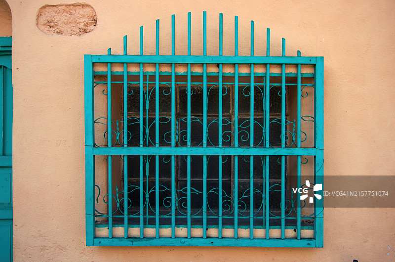 殖民风格房屋窗户上的装饰性木制和锻铁安全格栅图片素材