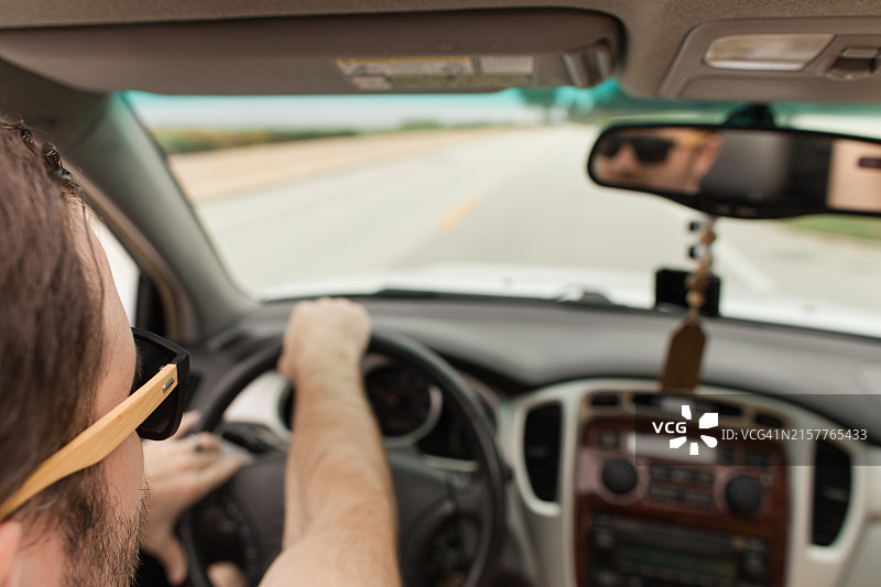 一位33岁的美国男子戴着太阳镜，在佛罗里达棕榈滩海边开着敞篷车兜风图片素材