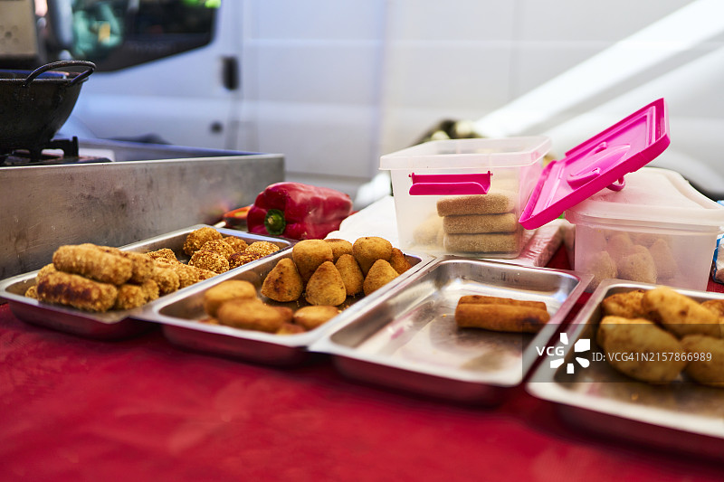 厨房桌子上放着炸物的金属托盘的正面照，周围没有人图片素材