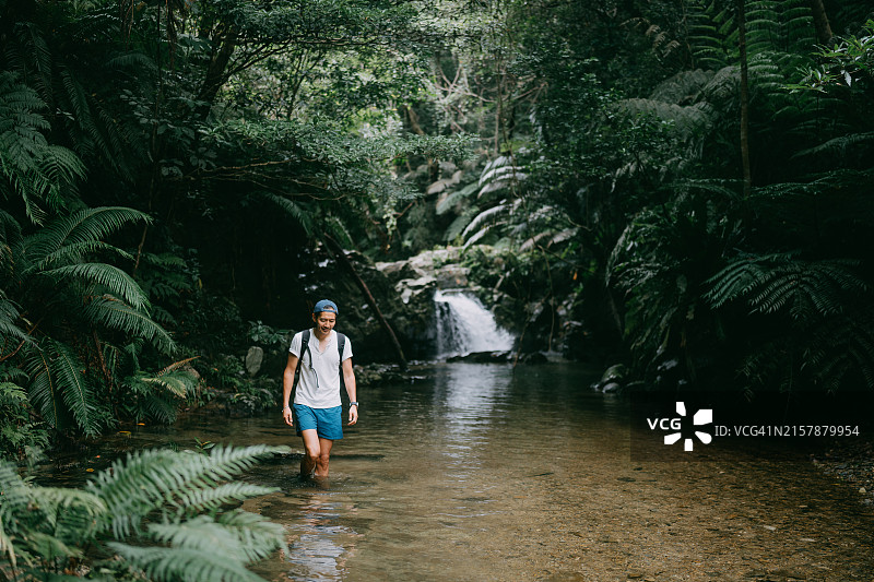 男子徒步穿越森林河流图片素材